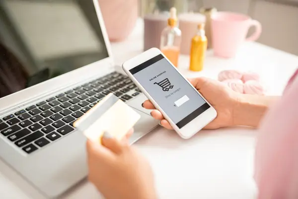 Frau mit Smartphone und Kreditkarte beim Onlineshopping