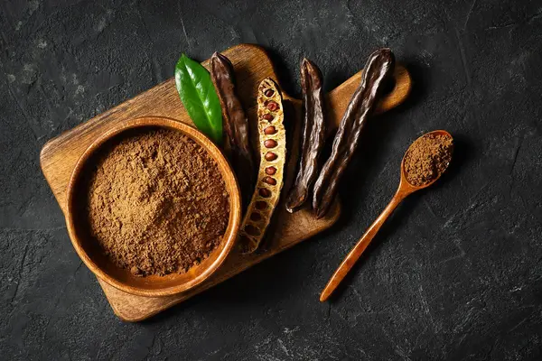 Carobpulver in einer Holzschüssel