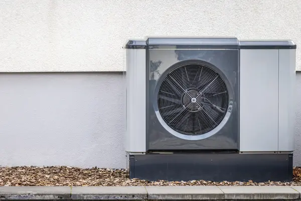 Eine Wärmepumpe an einer Hauswand.