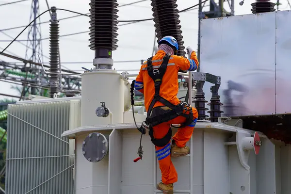 Elektriker bei Wartungsarbeiten an Transformator