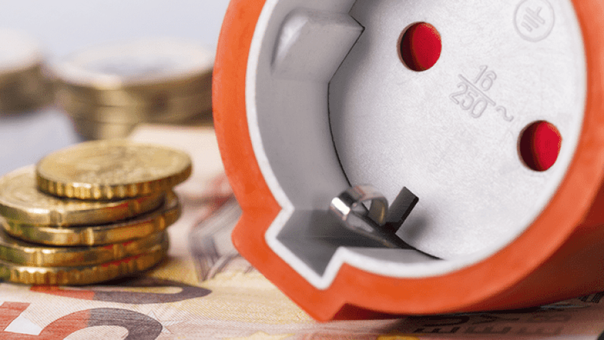 orangener Stecker liegt auf Bargeld