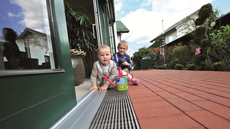 Zwei Kinder auf der Terrasse ohne Treppenübergang isn Wohnzimmer