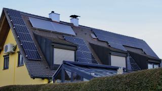 Hausdach mit Solaranlage: Photovoltaik-Module und Solarthermie-Kollektoren nebeneinander installiert.