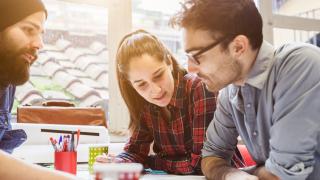 Drei Studenten arbeiten gemeinsam an einer Aufgabe